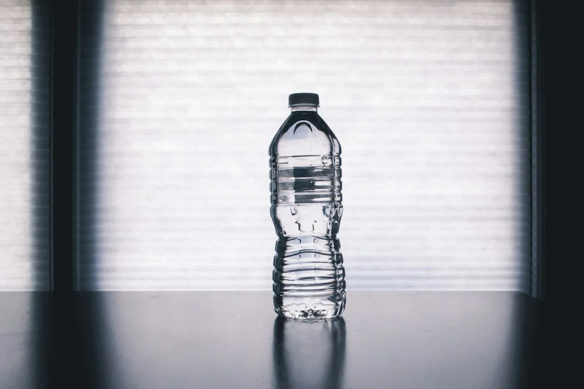 Clear glass bottle showing fine micro-bubbles of molecular hydrogen gas produced by electrolytic generator base